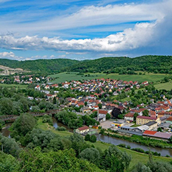 Siedlung umgeben von Wald und Feldern