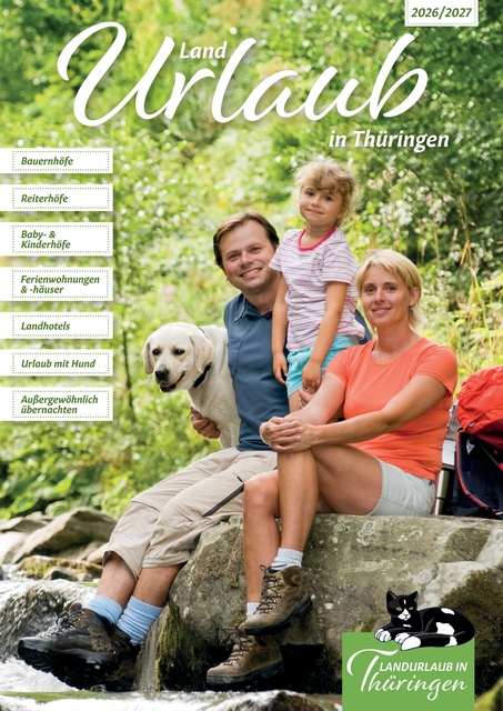 Familie mit Kind und Hund sitzt auf einem Stein am Waldrand, neben ihnen ein roter Rucksack.