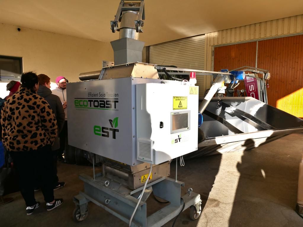 Eine Gruppe Menschen besichtigt ein großes technisches Gerät.
