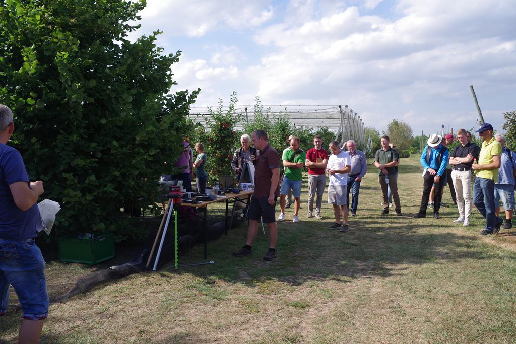 Besucher des Haselnusstages 2025 vor einer Versuchsanlage