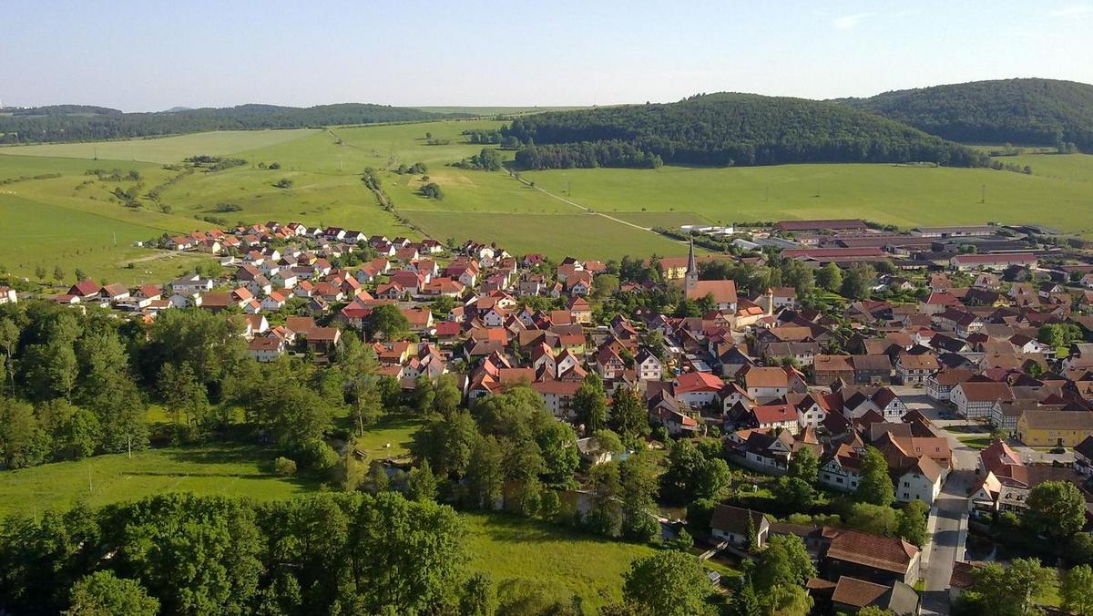 Dorf mit Landwirtschaftsbetrieb umgeben von Futterflächen