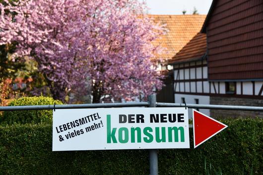 Schild "Der neue Konsum - Lebensmittel und Vieles mehr!"