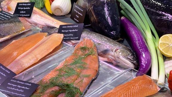 Frischer Fisch und Fischfilets mit Kräutern und Gemüse in einer Auslage