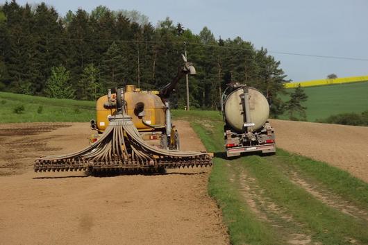 Betanken eines Terra Gator mit Gülle. Terragator steht auf einem abgeernteten Feld. Güllefaß steht daneben auf einem Feldweg.