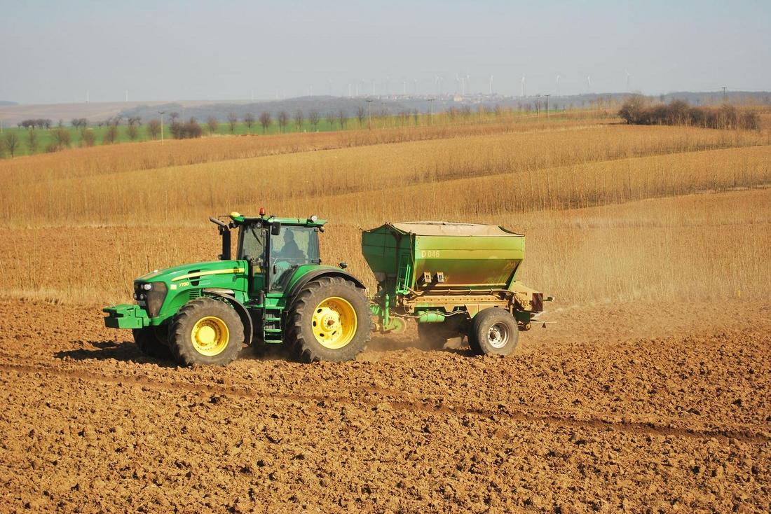 Traktor mit angebautem Düngerstreuer