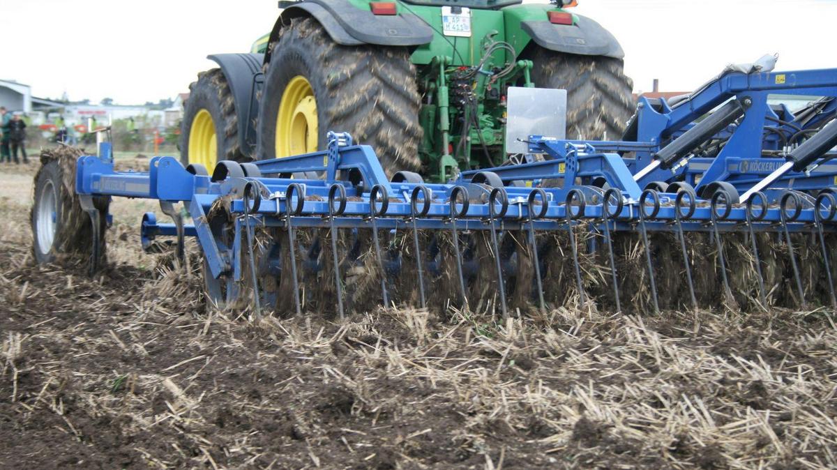 Traktor mit Grubber bei der Feldarbeit